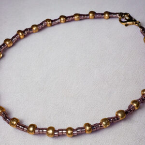 Large bracelet or anklet made of alternating purple and gold beads with a gold lobster claw clasp.