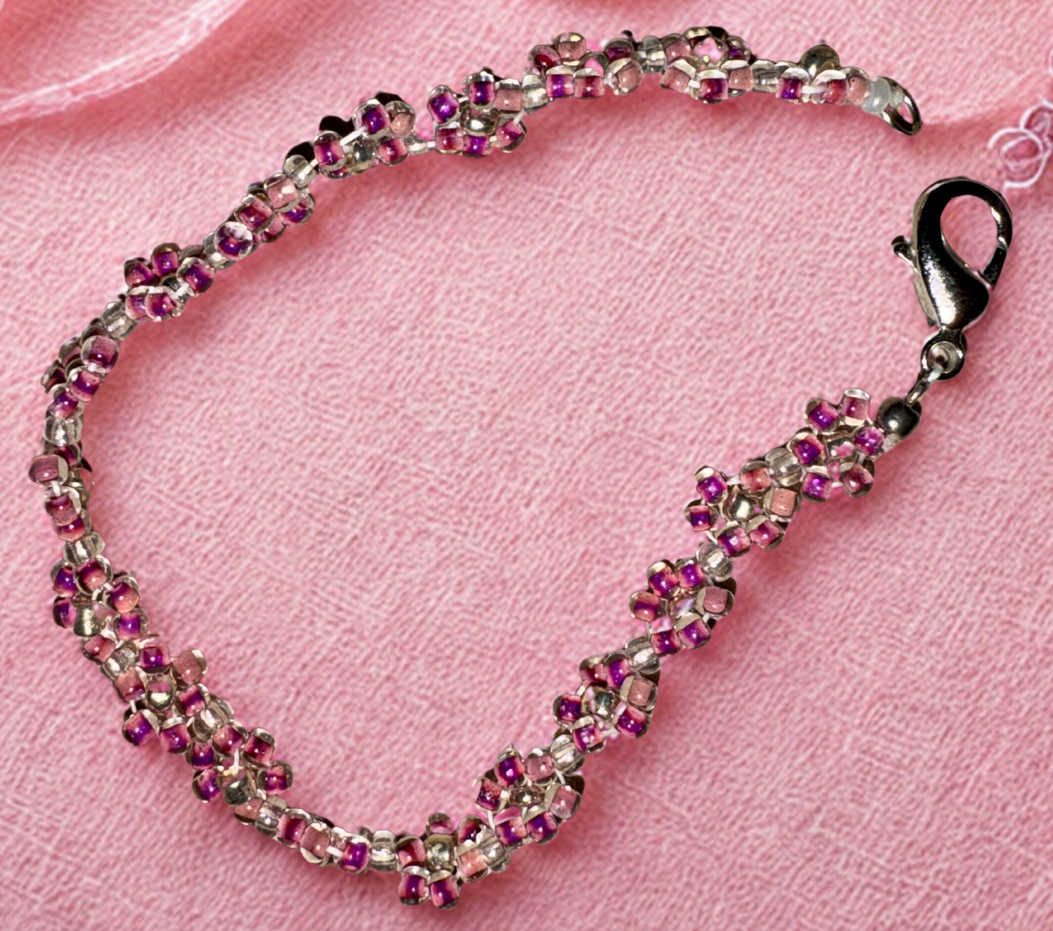 Small pink bracelet made with pink flower beads and a lobster claw clasp.