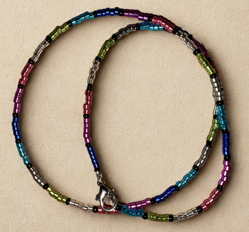 Medium length necklace, 16 inches with multicolored and black beading and a lobster claw clasp.