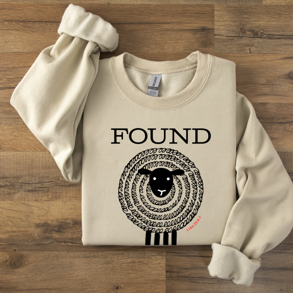 Sweatshirt folded on a table with the word FOUND over a black sheep