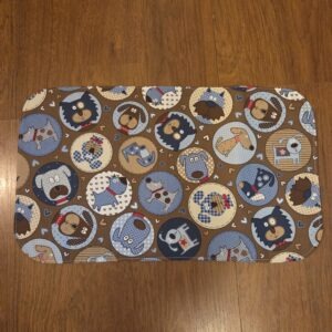 Pet food and water mat featuring adorable doggie print, plastic back to protect floors.