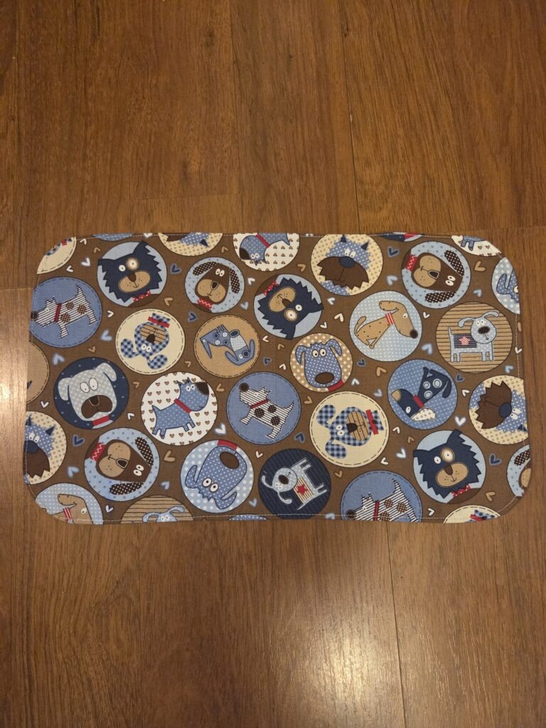 Pet food and water mat featuring adorable doggie print, plastic back to protect floors.