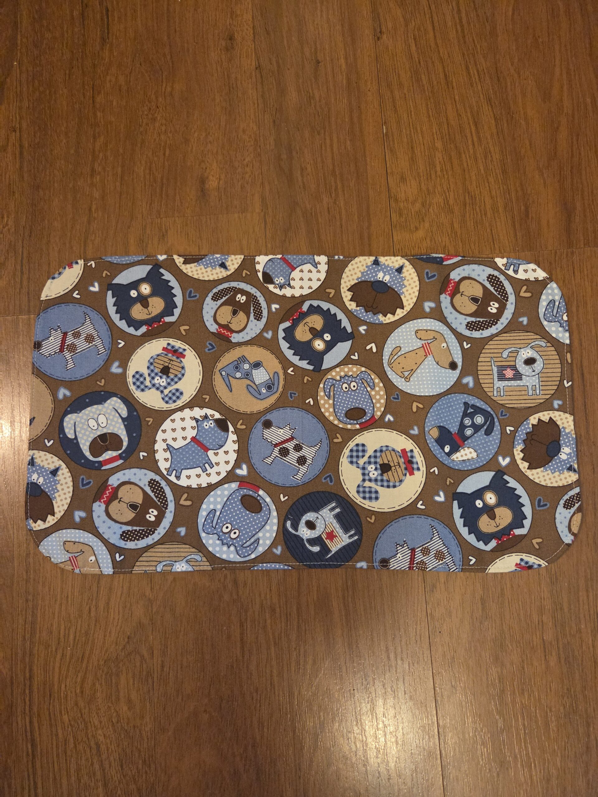Pet food and water mat featuring adorable doggie print, plastic back to protect floors.
