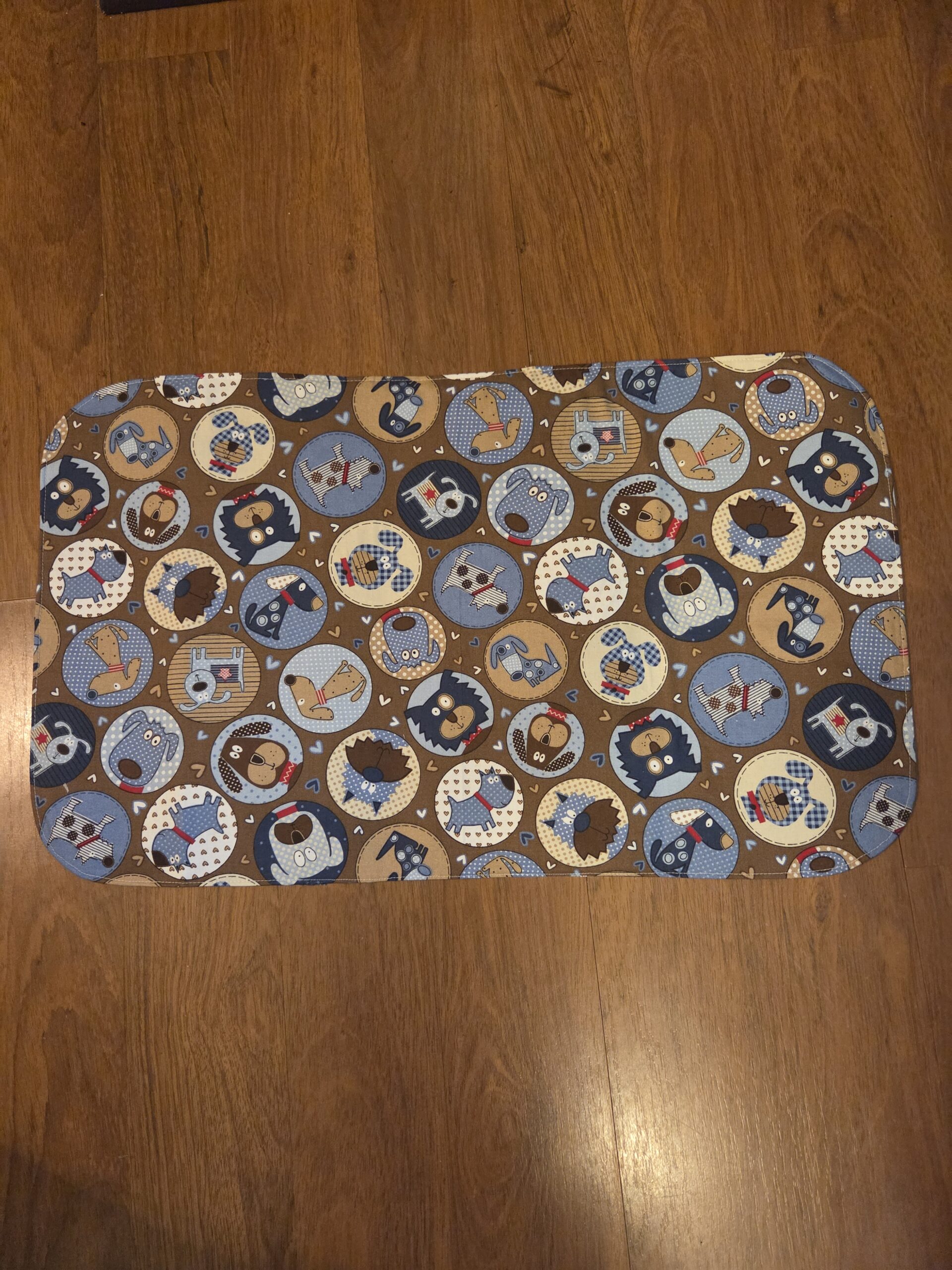 Blue & brown dog food and water bowl mat with plastic backing.