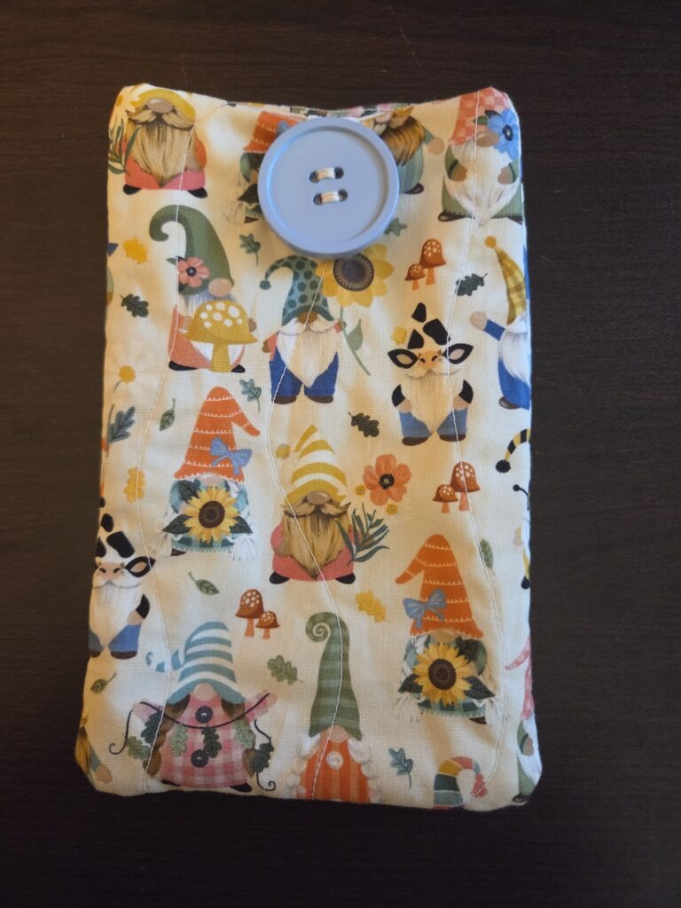 Gnome print padded cell phone case. Cotton, fully lined. Decorative blue button with elastic closure.