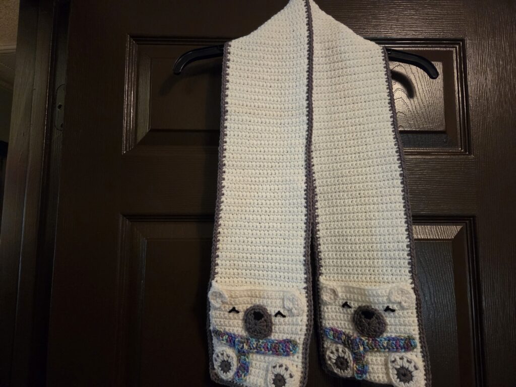Crochet scarf in winter white, featuring pockets with bears.