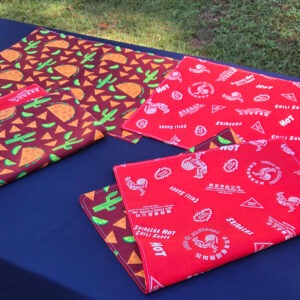 Taco Tuesday set of 4 placemats. Cotton, reversible. Top features tacos, chips, cacti, and lime slices. Bottom features Sriracha hot chili sauce logo.