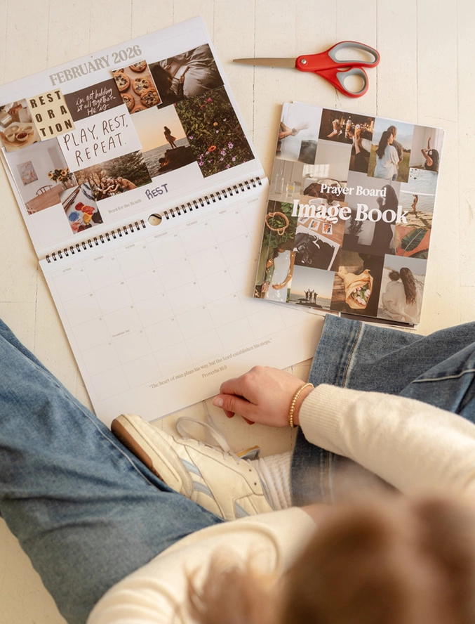 Woman sitting with prayer calendar opened and image book beside it