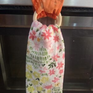 Bright orange kitchen towel hanger with wooden rings.