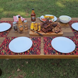 Set of 4 placemats, black, with red, orange, and yellow flames / Reversible. Back side features sriracha hot sauce pattern.