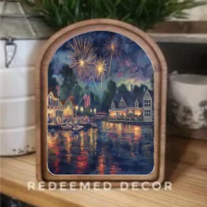 Art print showing fireworks over a body of water placed on a table