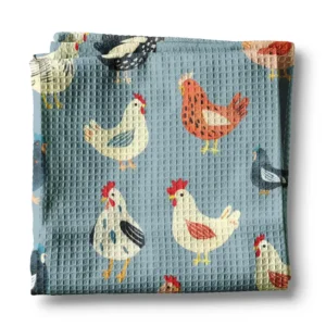Kitchen towel with chickens printed on a denim blue background