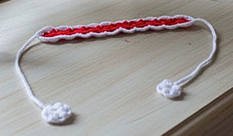 Red & White candy-striped hand crocheted headband for girls. Features handy balls at the ends of the tie.