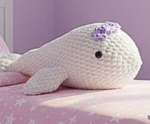 Echo the whale is hand crocheted in white, with a delicate soft purple bow on her head and safety eyes.