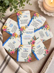 Floral Bible study discussion cards arranged in a circle beside a candle and greenery.